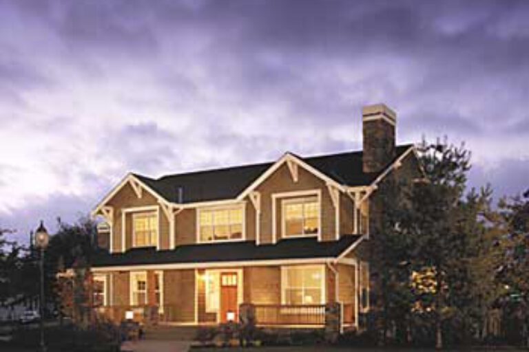 A two-story house with a gabled roof, prominent chimney, and porch illuminated by warm light. Dusk setting with vibrant purple clouds overhead.