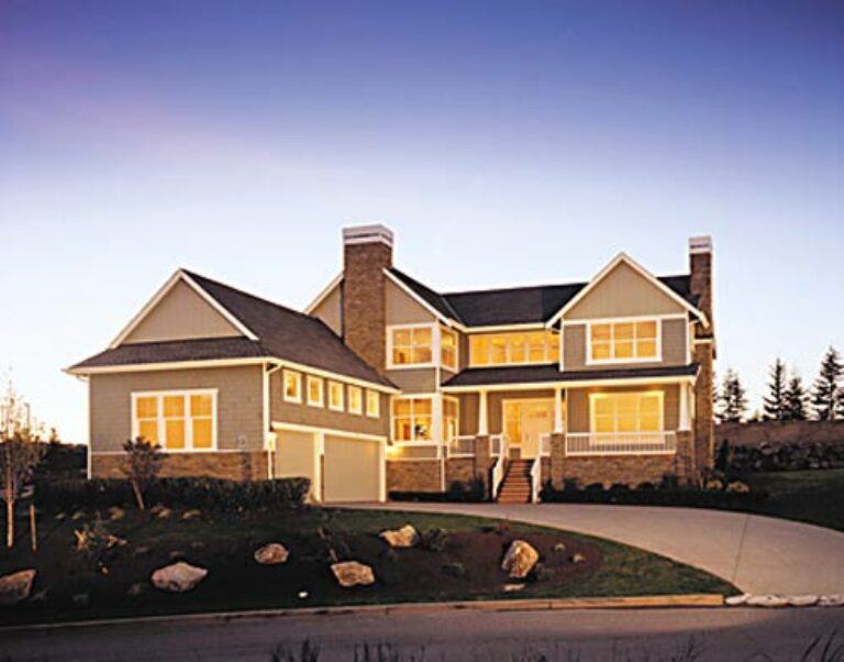  This image shows a large two-story suburban house with a gable roof, double chimneys, a front porch, and an attached garage during twilight. 